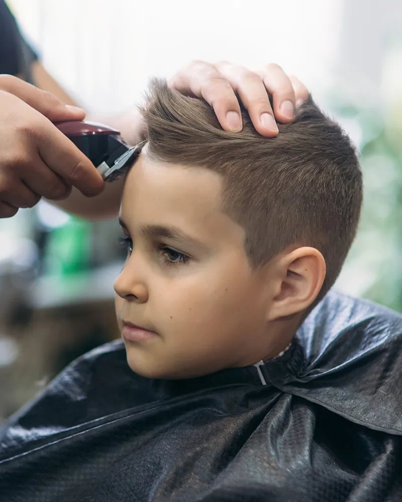 Boy getting a clipper haircut at Robert's Salon and Spa in Belmont, MA