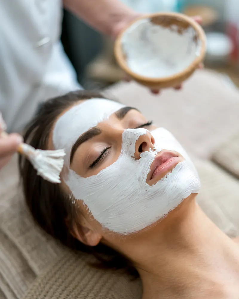 Esthetician applying a facial mask at Robert's Salon and Spa in Belmont, MA